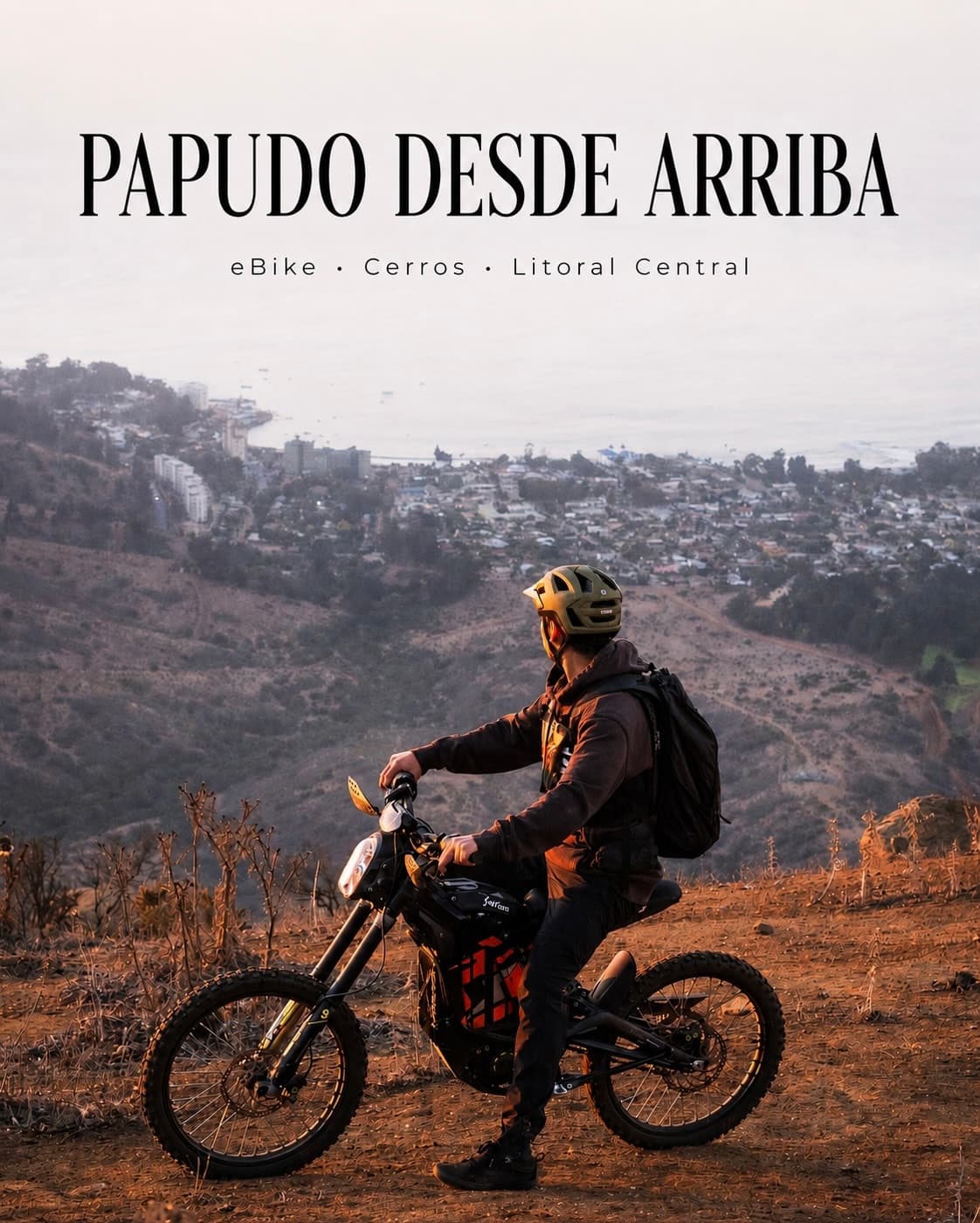 Ciclista en eBike mirando la bahía de Papudo desde los cerros al atardecer